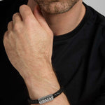 closeup image of black leather silver Celtic bracelet on a male model