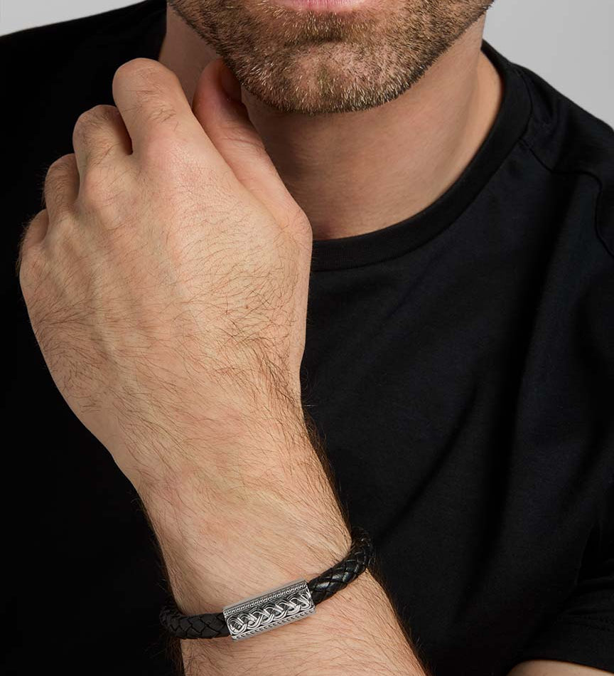 closeup image of black leather silver Celtic bracelet on a male model