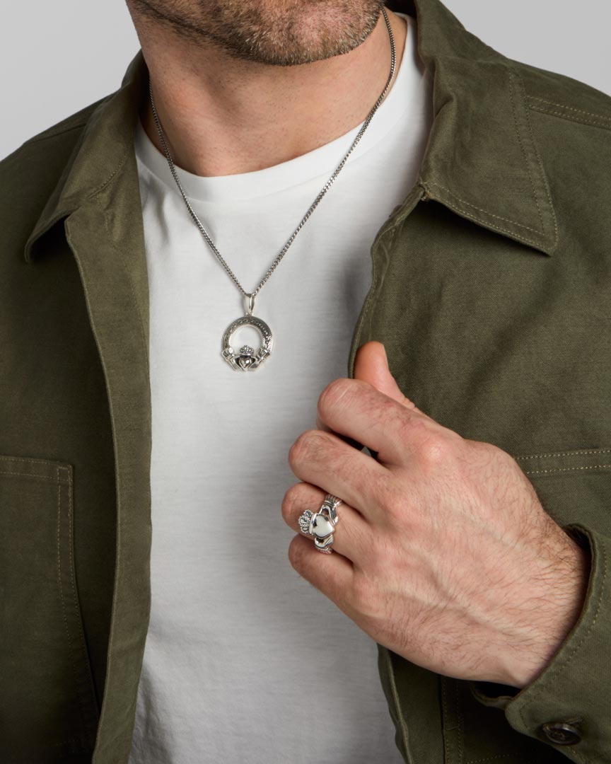 oxidised silver men's heavy Celtic Claddagh ring and matching necklace set on a model