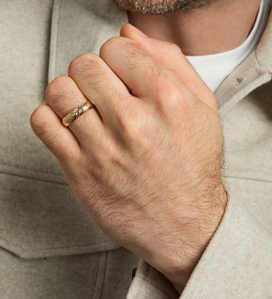 closeup image of men's gold claddagh wedding band ring