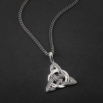 lifestyle image of large men's celtic knot pendant on a heavy silver flat curb chain 
