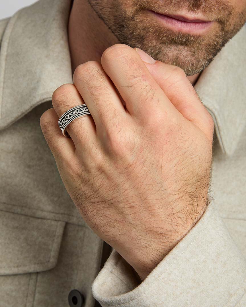 closeup image of men's silver Celtic Knot band ring on a model