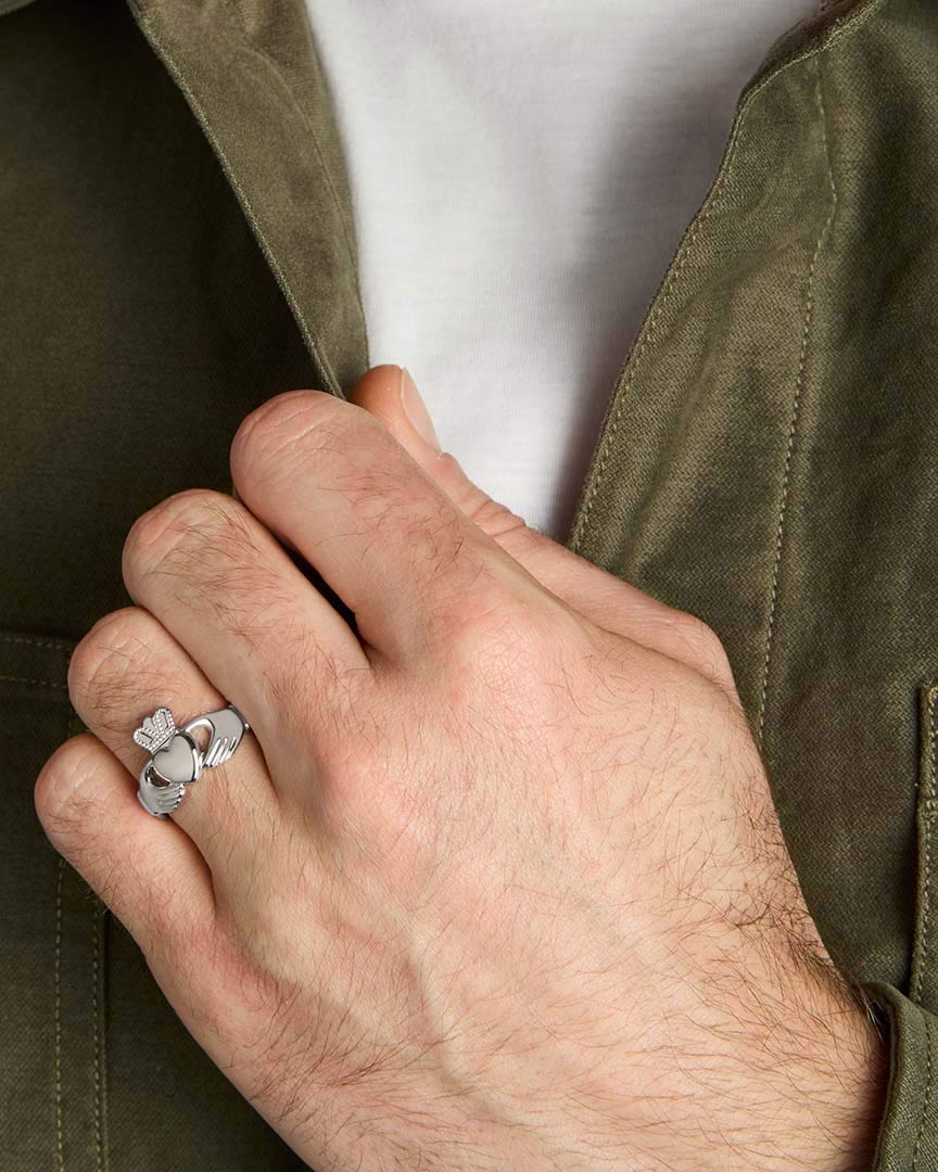 closeup image of mens silver claddagh ring on a model