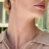 Close-up of a woman wearing Celtic Trinity Knot earrings and necklace set from Solvar