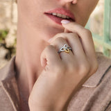 Close-up image mixed metal Celtic ring on a model outdoors.