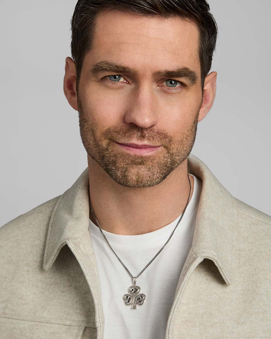 a model wearing men's silver Celtic Shamrock pendant on heavy silver chain from Solvar