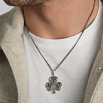 closeup image of oxidised silver men's heavy Celtic shamrock pendant on a model