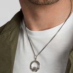 closeup image of men's silver Celtic Claddagh necklace on a model
