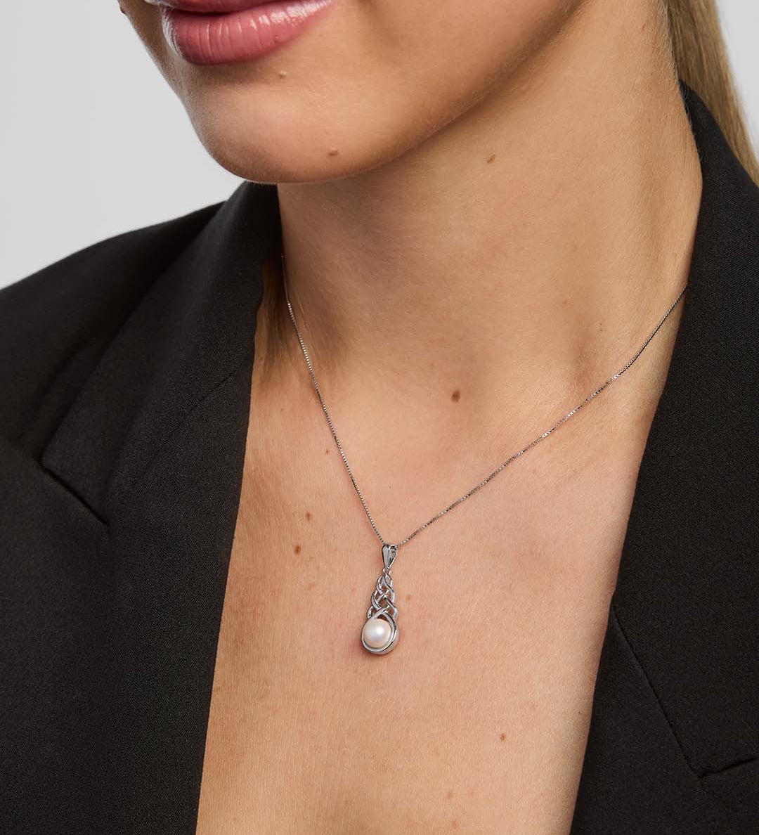 close-up image of a woman wearing Celtic knot necklace with a large round freshwater pearl in the centre