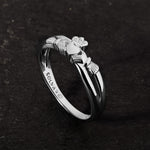 lifestyle image of promise Claddagh ring on a dark stone background