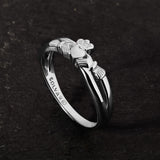 lifestyle image of promise Claddagh ring on a dark stone background