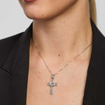 Person wearing a silver Claddagh cross necklace with a black blazer