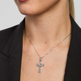 Person wearing a silver Claddagh cross necklace with a black blazer