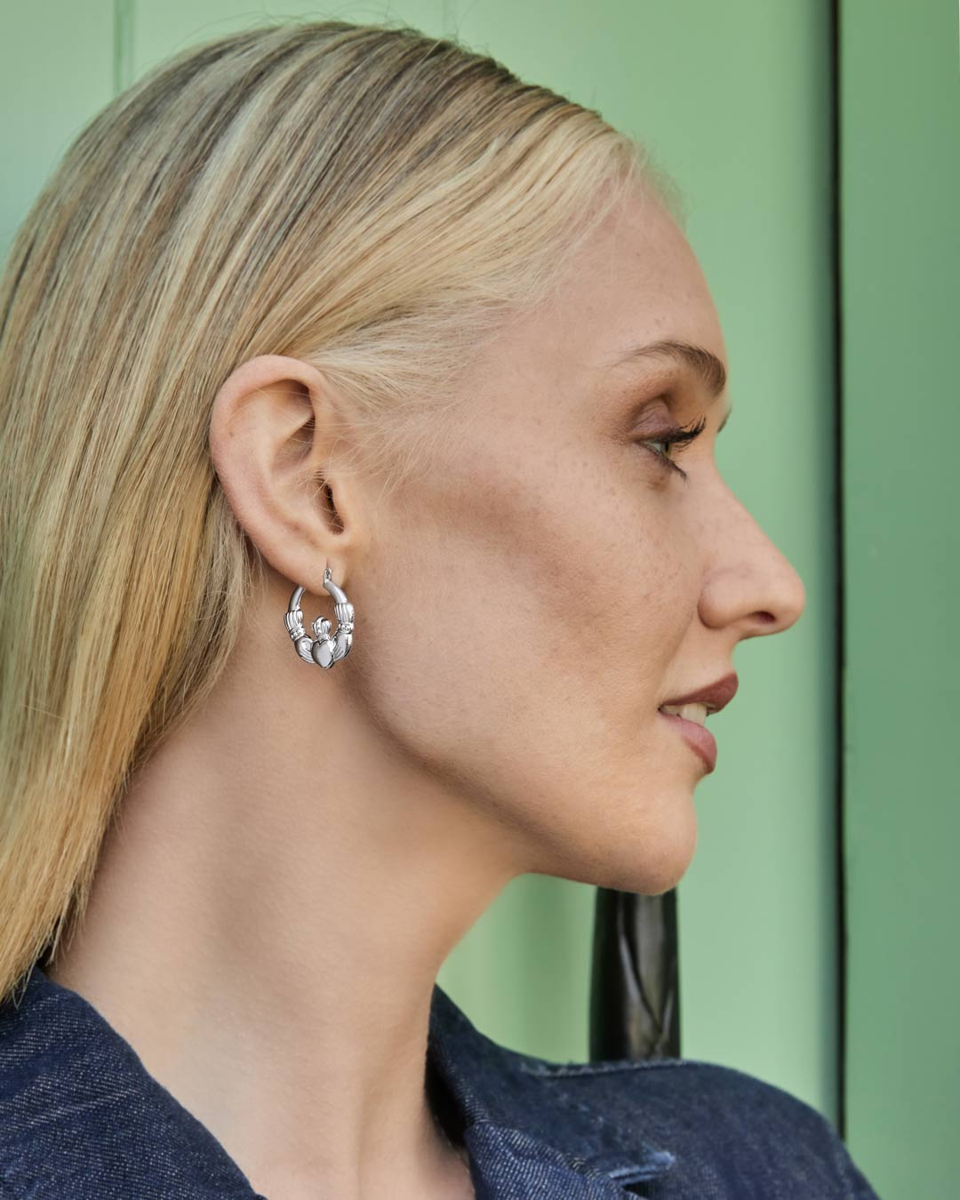 model wearing Claddagh hoop earrings in silver