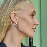 model wearing Claddagh hoop earrings in silver