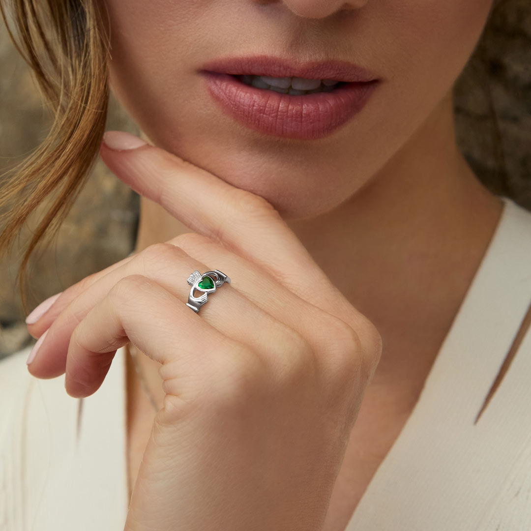 styled image of sterling silver claddagh emerald ring s2594 on a model 1