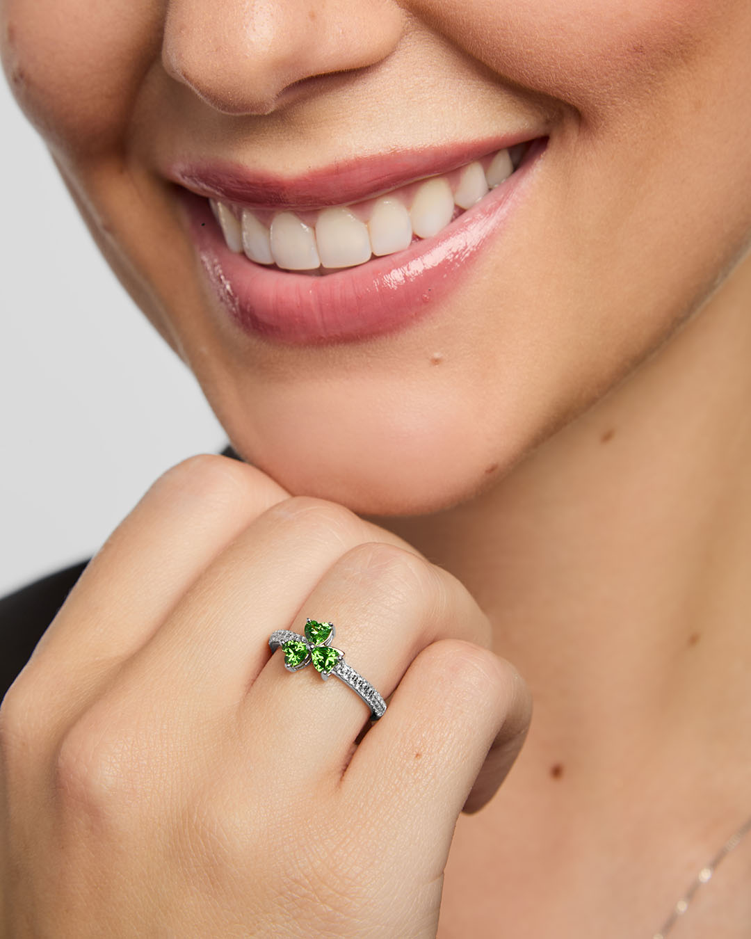 close-up image of green cubic zirconia silver Shamrock ring on a model 