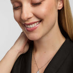 A close-up portrait of a female wearing a dark top and a fine chain necklace, featuring small map of Ireland pendant from Solvar, centred on the chest.
