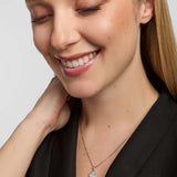 A close-up portrait of a female wearing a dark top and a fine chain necklace, featuring small map of Ireland pendant from Solvar, centred on the chest.