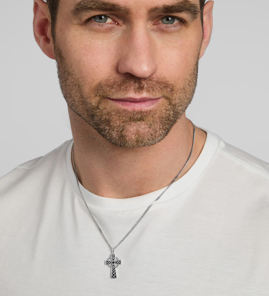 a male model wearing oxidised silver Celtic cross pendant on a heavy chain from Solvar
