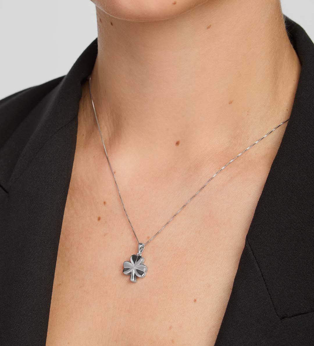 close-up image of  a female model wearing shiny silver Shamrock pendant 