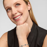 lifestyle image of a female model wearing green cubic zirconia trinity knot bracelet from Solvar
