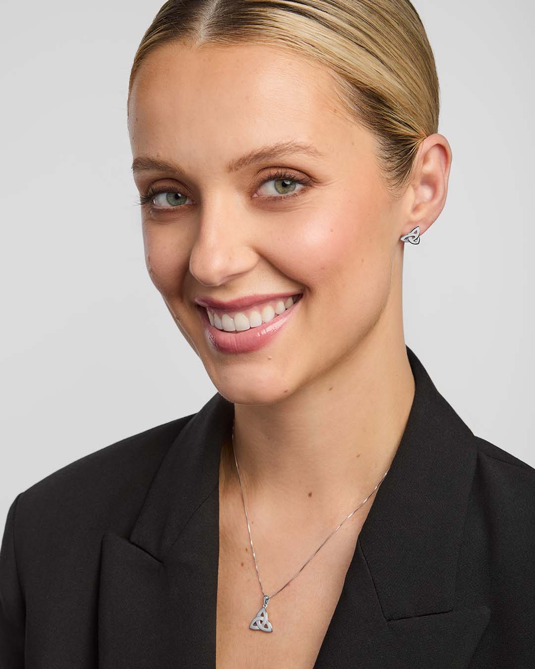 a female model wearing trinity knot jewellery set in silver