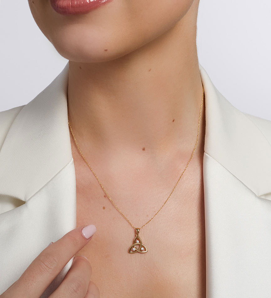 open cz gold trinity knot pendant on a model 1