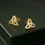 lifestyle image of yellow gold trinity knot earrings